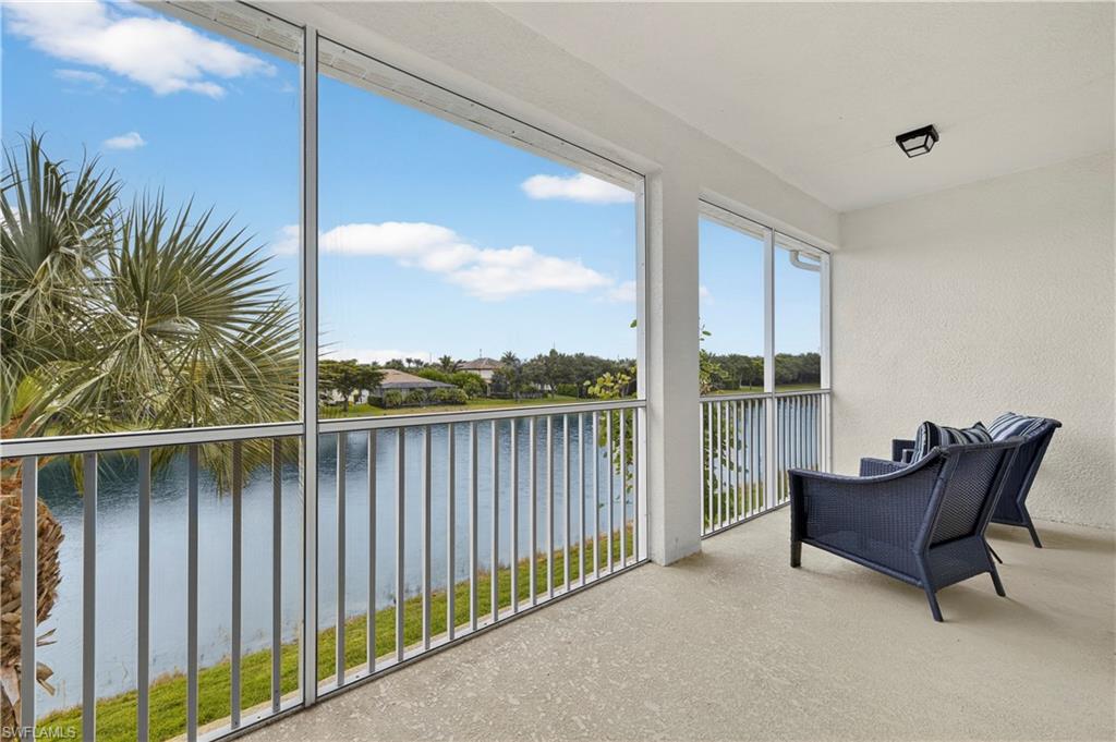2319 Sawyers Hill Road, Unit 705 Naples, FL 34102 - Photo 26 of 29 Sunroom with a water view, speckled floor, and a textured wall