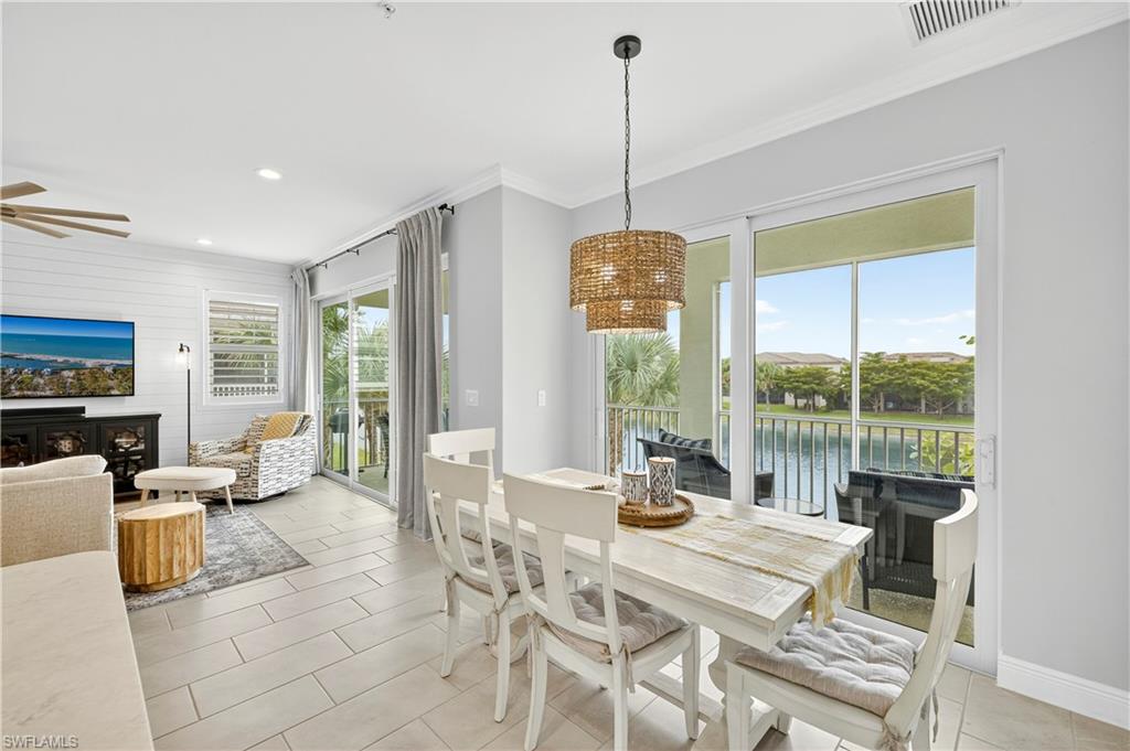 2319 Sawyers Hill Road, Unit 705 Naples, FL 34102 - Photo 7 of 29 Dining room featuring ornamental molding, light tile patterned flooring, recessed lighting, a water view, and wooden walls