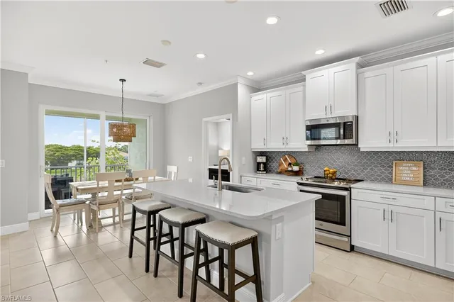a kitchen with appliances cabinets and chair