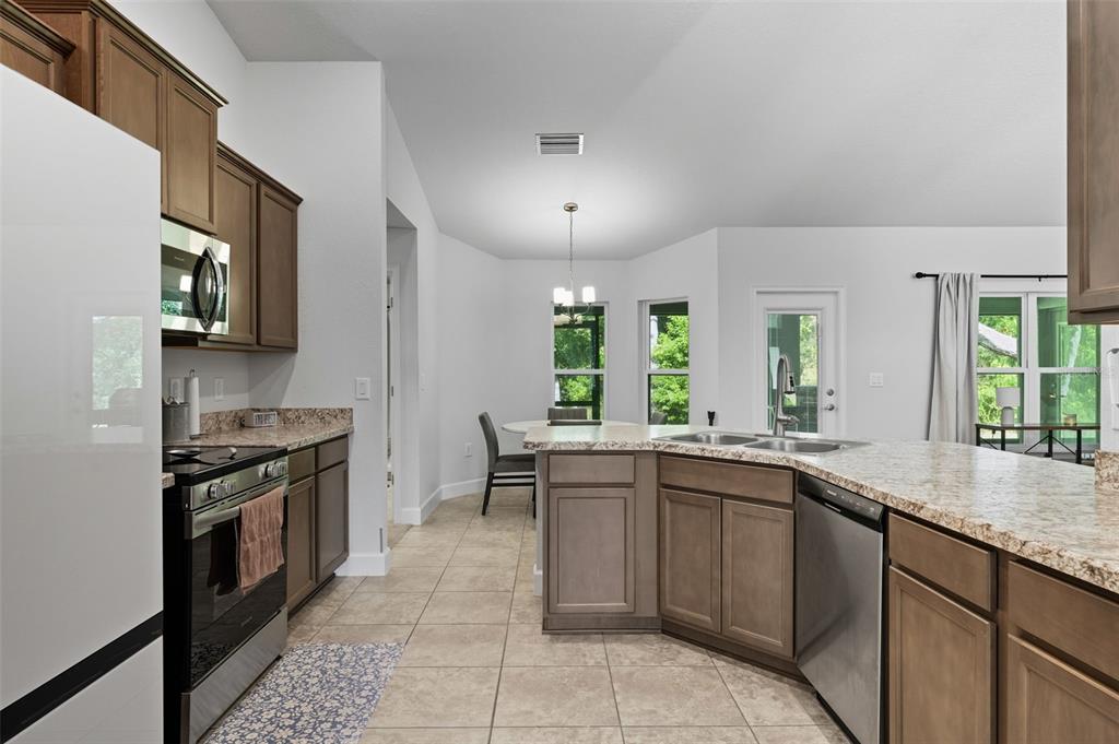 463 Trafalgar Lane Spring Hill, FL 34606 - Photo 15 of 36 a kitchen with a sink stove and cabinets