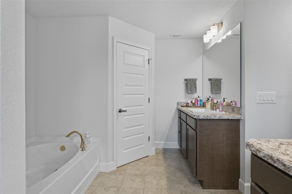 463 Trafalgar Lane Spring Hill, FL 34606 - Photo 24 of 36 a bathroom with a granite countertop sink and a mirror