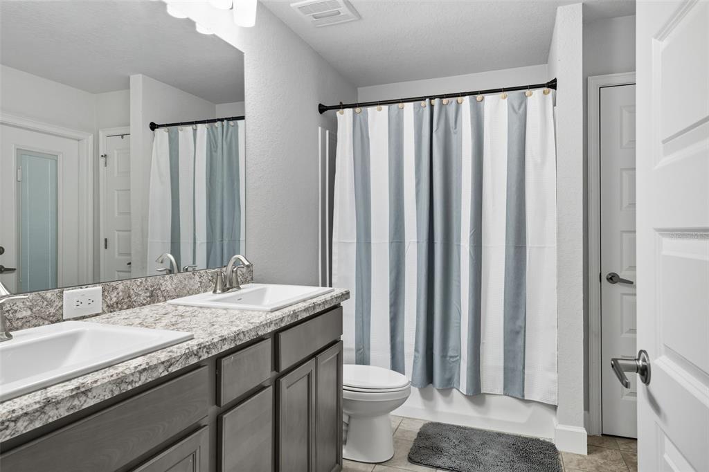 463 Trafalgar Lane Spring Hill, FL 34606 - Photo 27 of 36 a bathroom with a granite countertop sink and a mirror