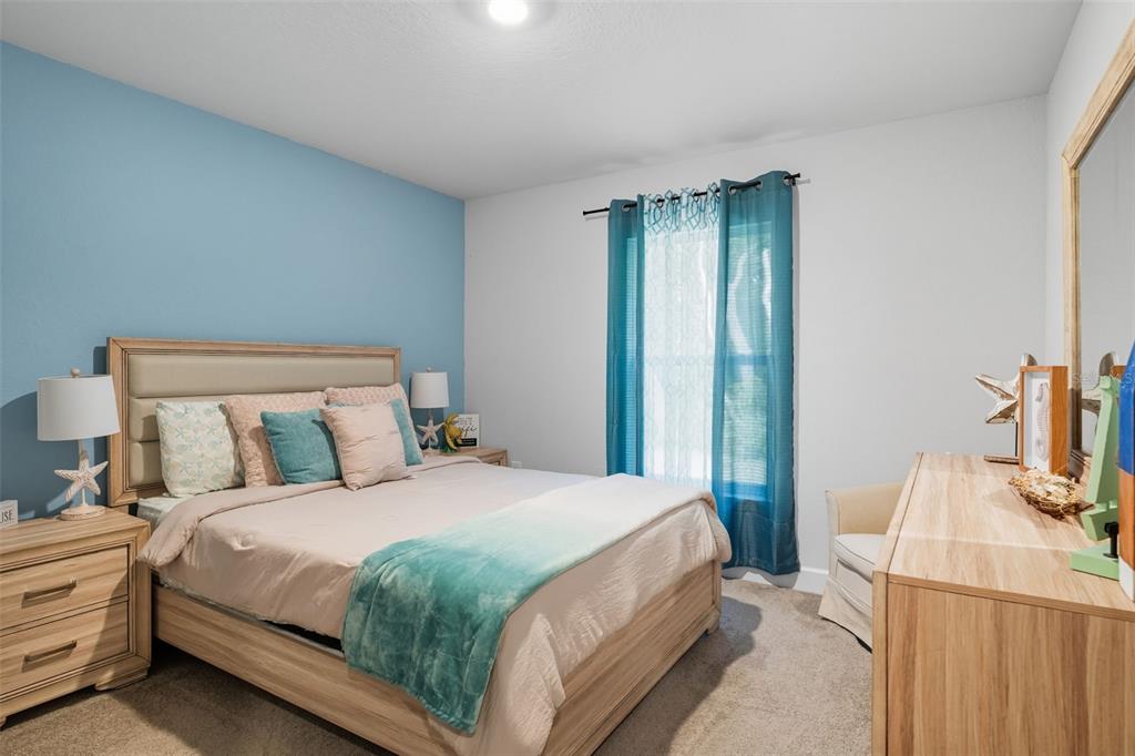 463 Trafalgar Lane Spring Hill, FL 34606 - Photo 28 of 36 a bedroom with a bed and a flat tv screen on a dresser