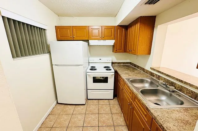 a kitchen with a stove a sink and a refrigerator