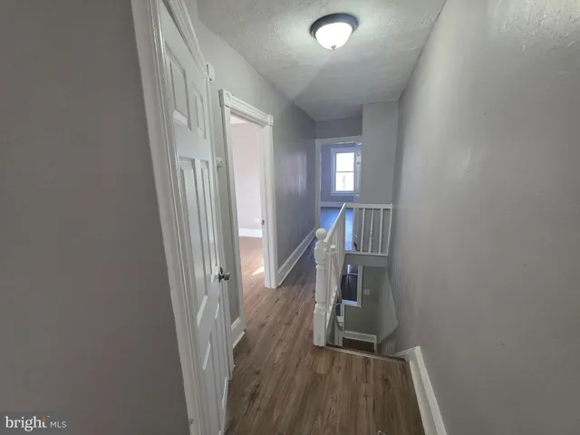 a view of hallway with stairs and wooden floor