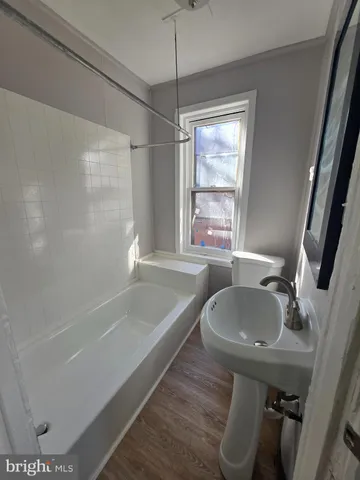a bathroom with a tub sink and mirror