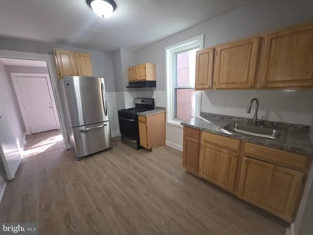 a kitchen with stainless steel appliances granite countertop a refrigerator microwave and sink