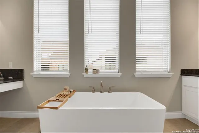 a white bath tub sitting in a bathroom next to a window