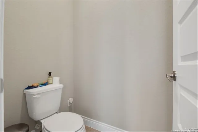 a white toilet sitting next to a white wall