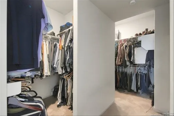 a view of walk in closet with clothes
