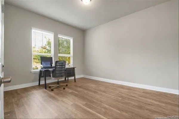 a view of a workspace with furniture and a window