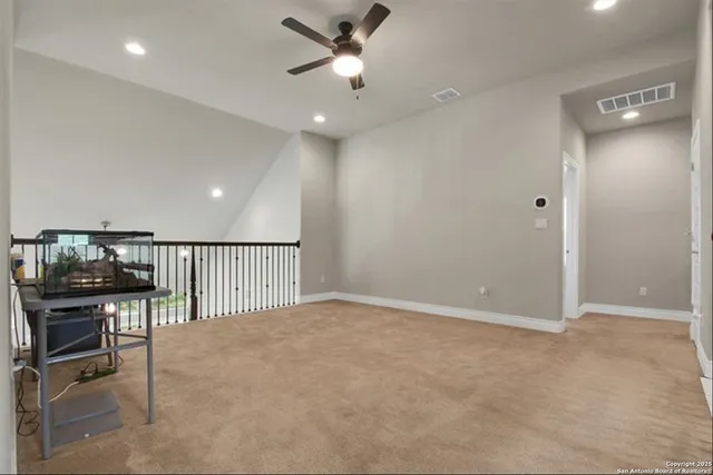 an empty room with windows and ceiling fan