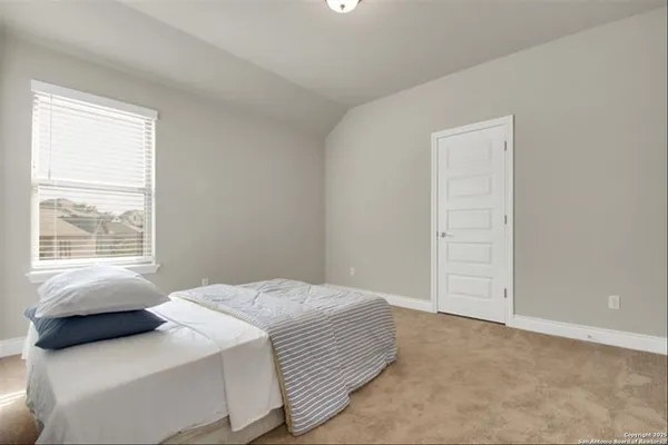 a bedroom with a bed and a window