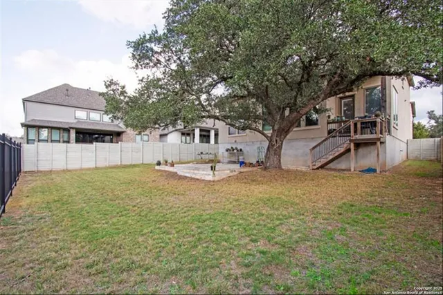 a view of a house with backyard and tree