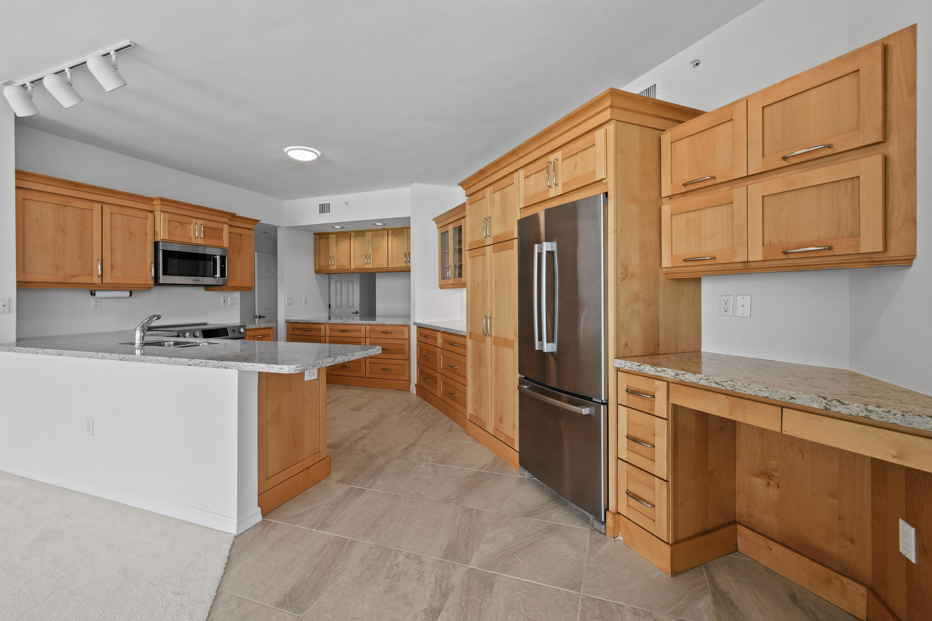 1660 Florida A1A, Unit 352 Jupiter, FL 33477 - Photo 7 of 36 a kitchen with stainless steel appliances granite countertop a refrigerator and a stove top oven