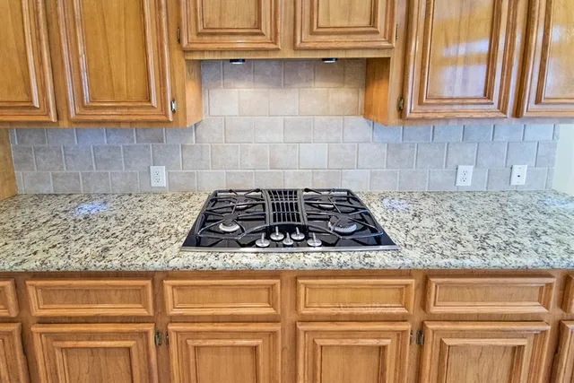 a kitchen with granite countertop white cabinets and stainless steel appliances