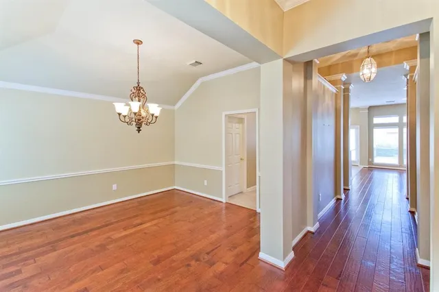 a view of a room with wooden floor and chandelier