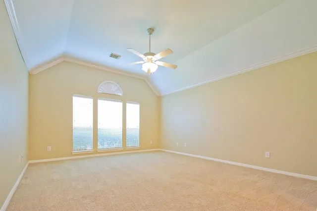 a view of an empty room with chandelier fan and fire place