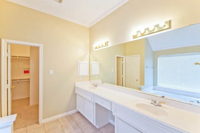 a bathroom with a double vanity sink a mirror and a bathtub