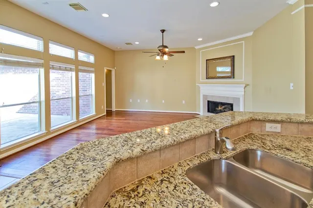 a view of a kitchen with a sink and dishwasher with a fireplace