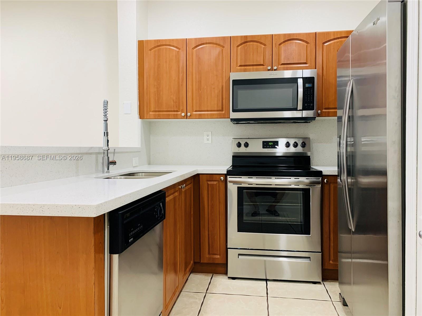 7250 Northwest 177th Street, Unit 208 Hialeah, FL 33015 - Photo 3 of 13 a kitchen with stainless steel appliances a stove microwave and sink