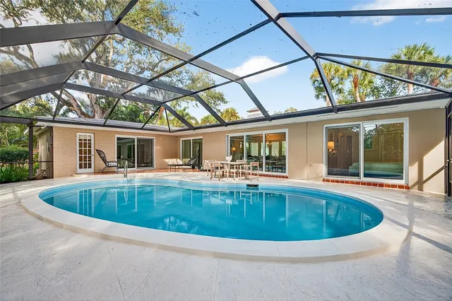 a view of house with swimming pool and outdoor seating