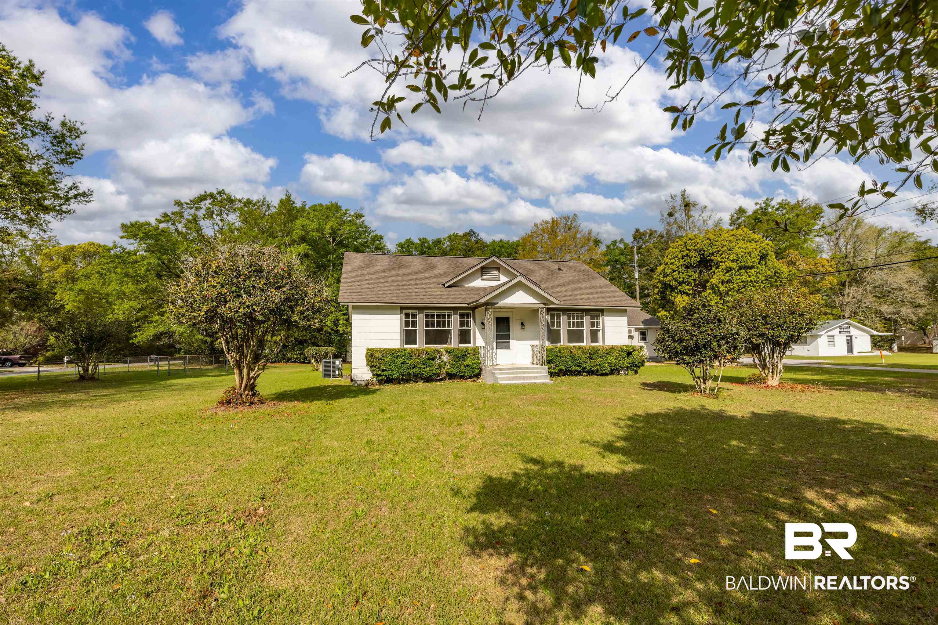 112 South Juniper Street Foley, AL 36535 - Photo 3 of 64 Ranch-style home featuring a front lawn and view of scattered trees