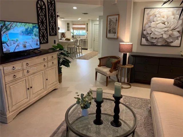 a living room with furniture a window and a potted plant