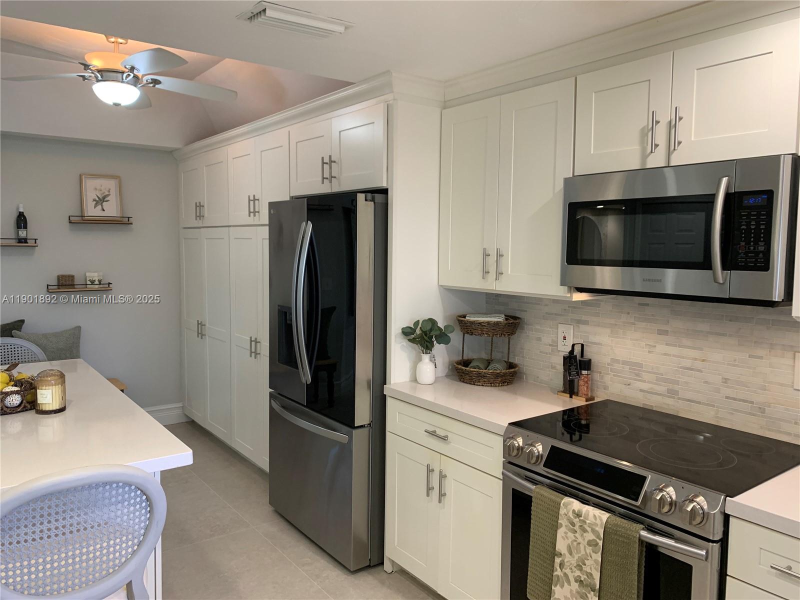 6102 Southeast Landing Way, Unit 2 Stuart, FL 34997 - Photo 4 of 51 a kitchen with stainless steel appliances a stove microwave and sink