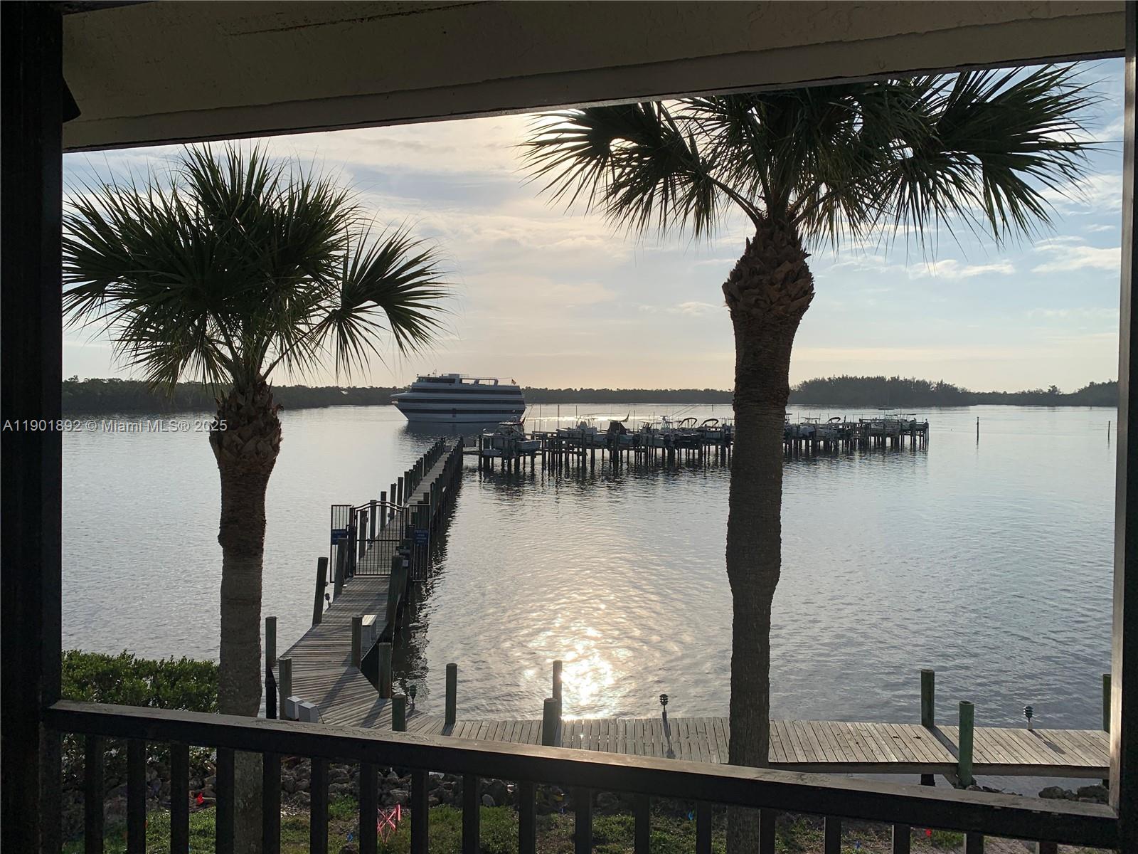 6102 Southeast Landing Way, Unit 2 Stuart, FL 34997 - Photo 47 of 51 a view of a lake with a palm tree