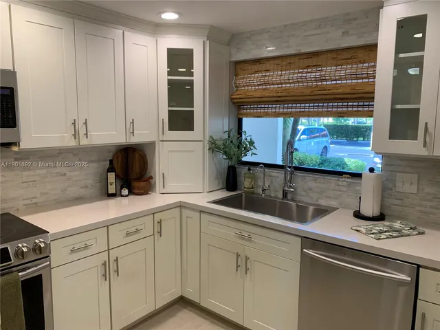 a room with a potted plant and kitchen view