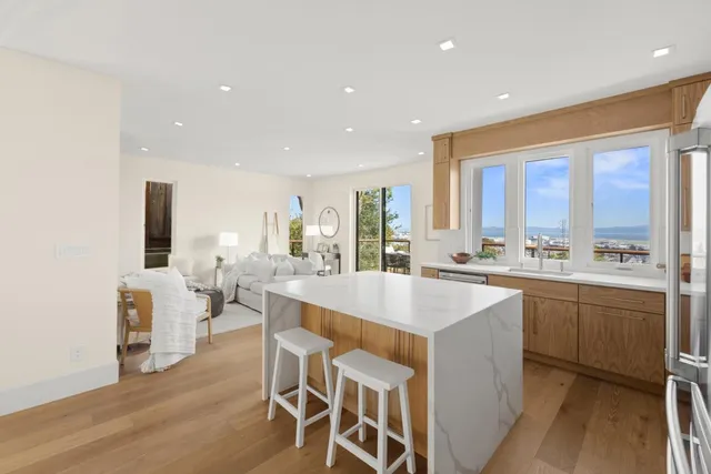 a large kitchen with kitchen island a sink table and chairs