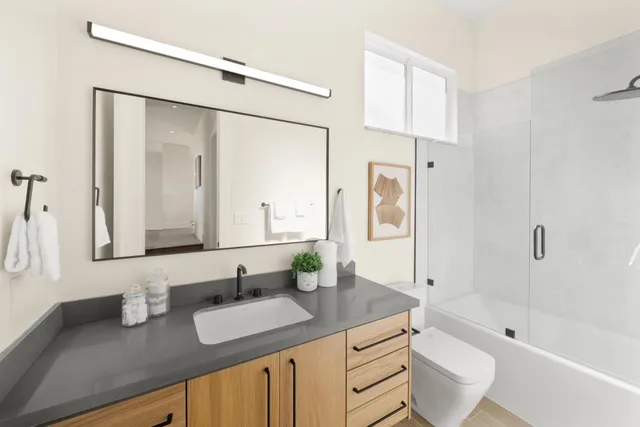 a bathroom with a granite countertop sink mirror toilet and bathtub