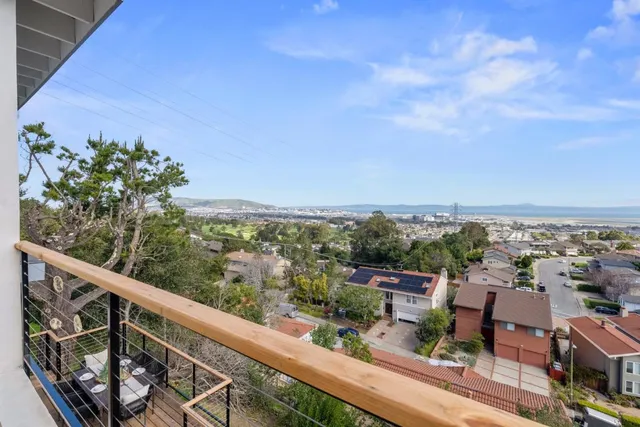 a view of a city from a balcony with furniture