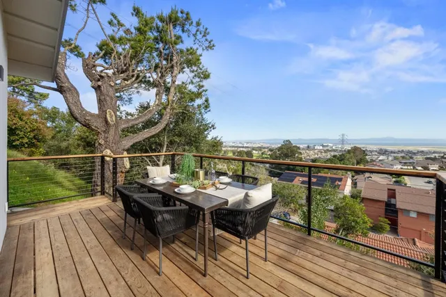 a view of a balcony with wooden floor and outdoor seating