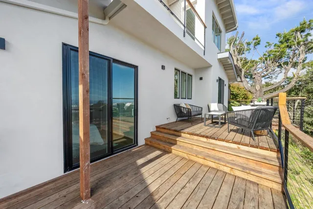a view of a balcony with chairs and wooden floor