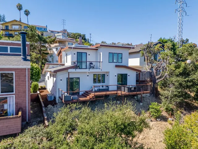 a view of a house with a yard chairs and table in a patio