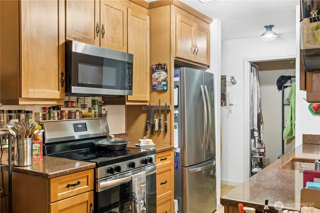a kitchen with stainless steel appliances granite countertop a refrigerator stove and microwave