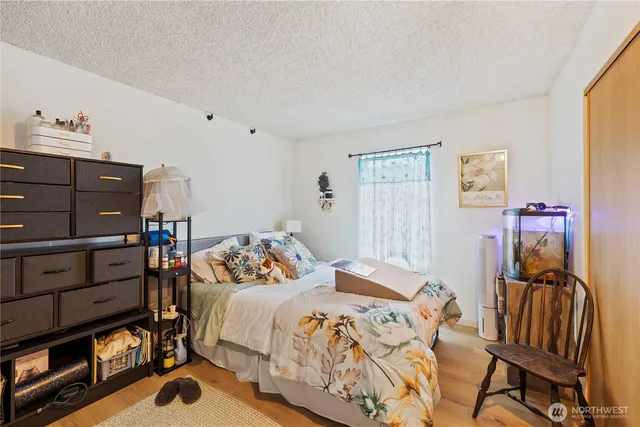 a bedroom with a bed and wooden floor
