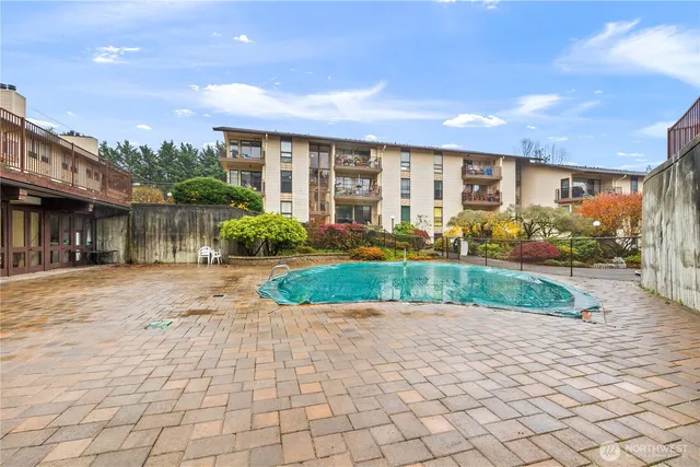 a front view of a building with a yard and potted plants