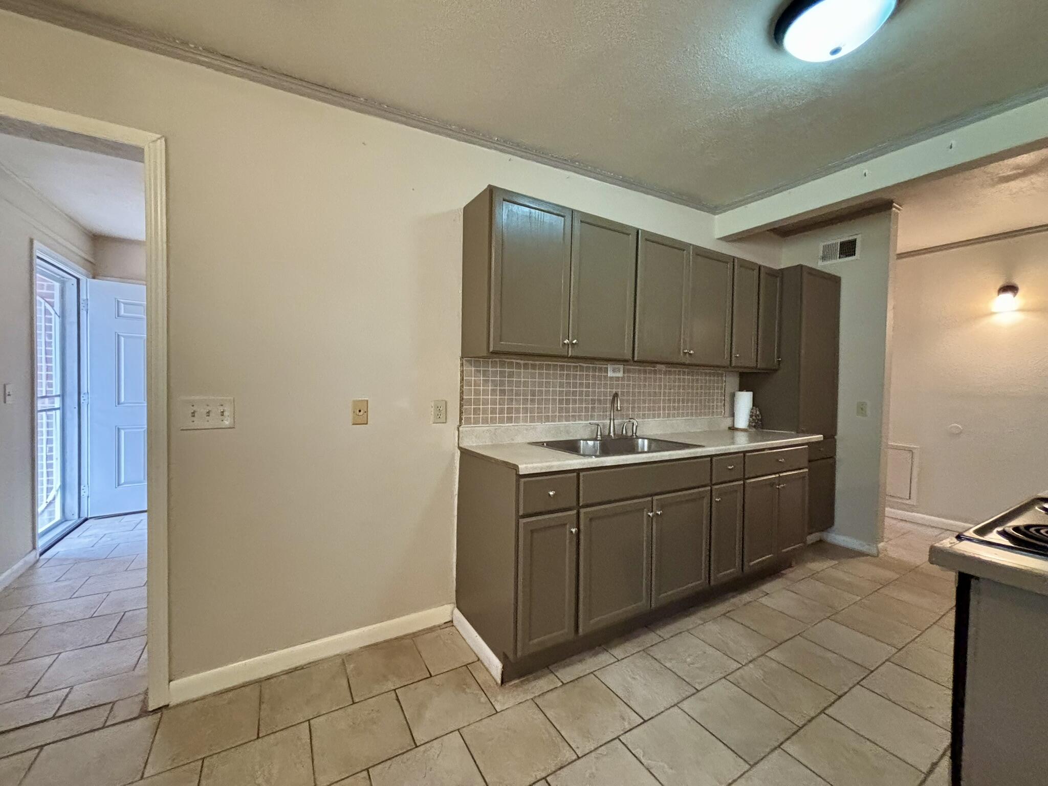 2313 47th Street Lubbock, TX 79412 - Photo 6 of 17 a kitchen with granite countertop a sink and cabinets