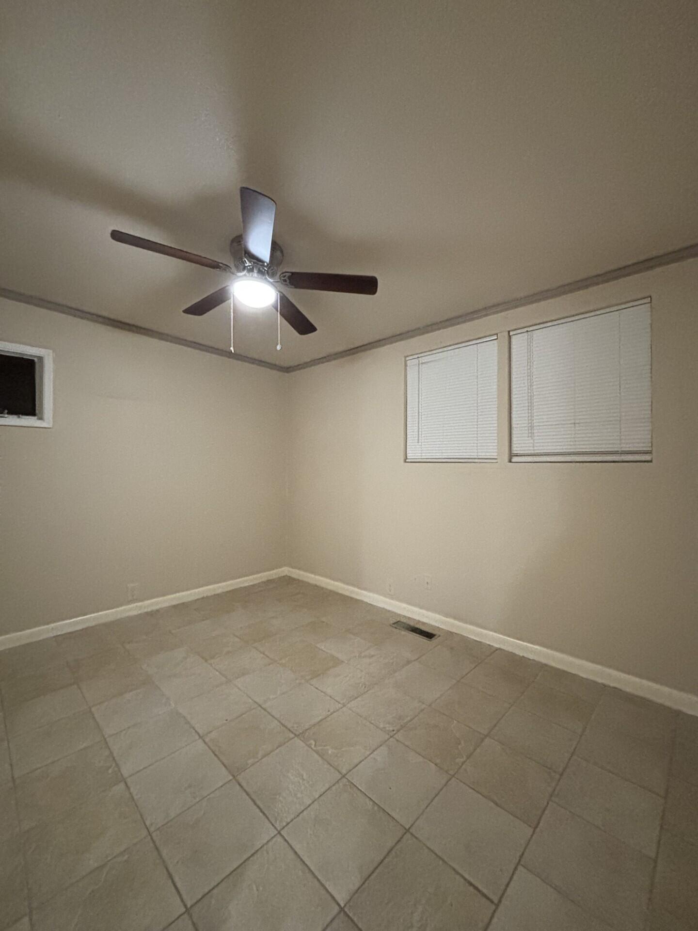 2313 47th Street Lubbock, TX 79412 - Photo 10 of 17 an empty room with a chandelier fan and windows