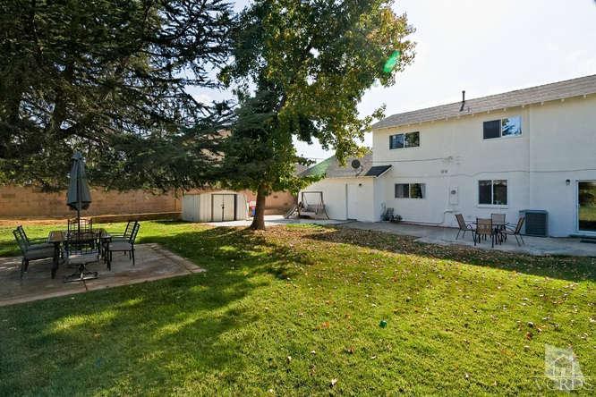 2973 Fitzgerald Road Simi Valley, CA 93065 - Photo 17 of 19 a view of a backyard with table and chairs and a large tree