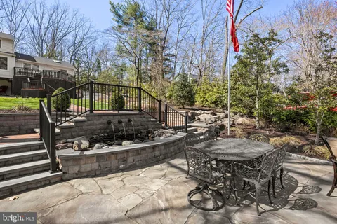 a view of a swimming pool with lounge chairs and a small yard
