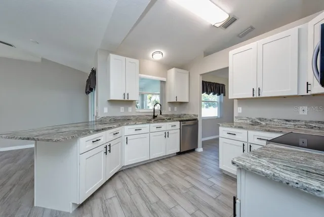 a kitchen with granite countertop wooden cabinets and white appliances