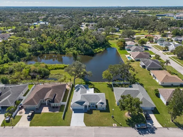 an aerial view of residential houses with outdoor space and lake view