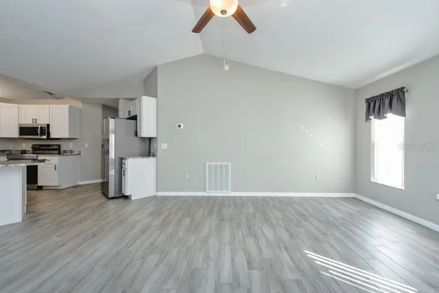 a view of a kitchen with a sink a refrigerator and window
