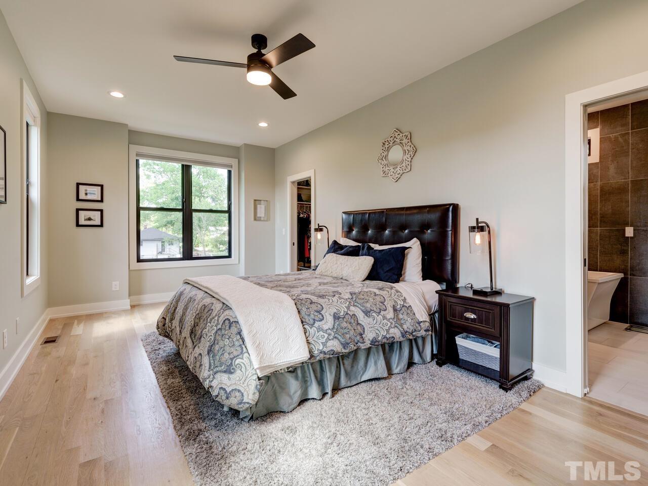 220 Hargrove Street Durham, NC 27701 - Photo 34 of 76 a bedroom with a bed and a chandelier