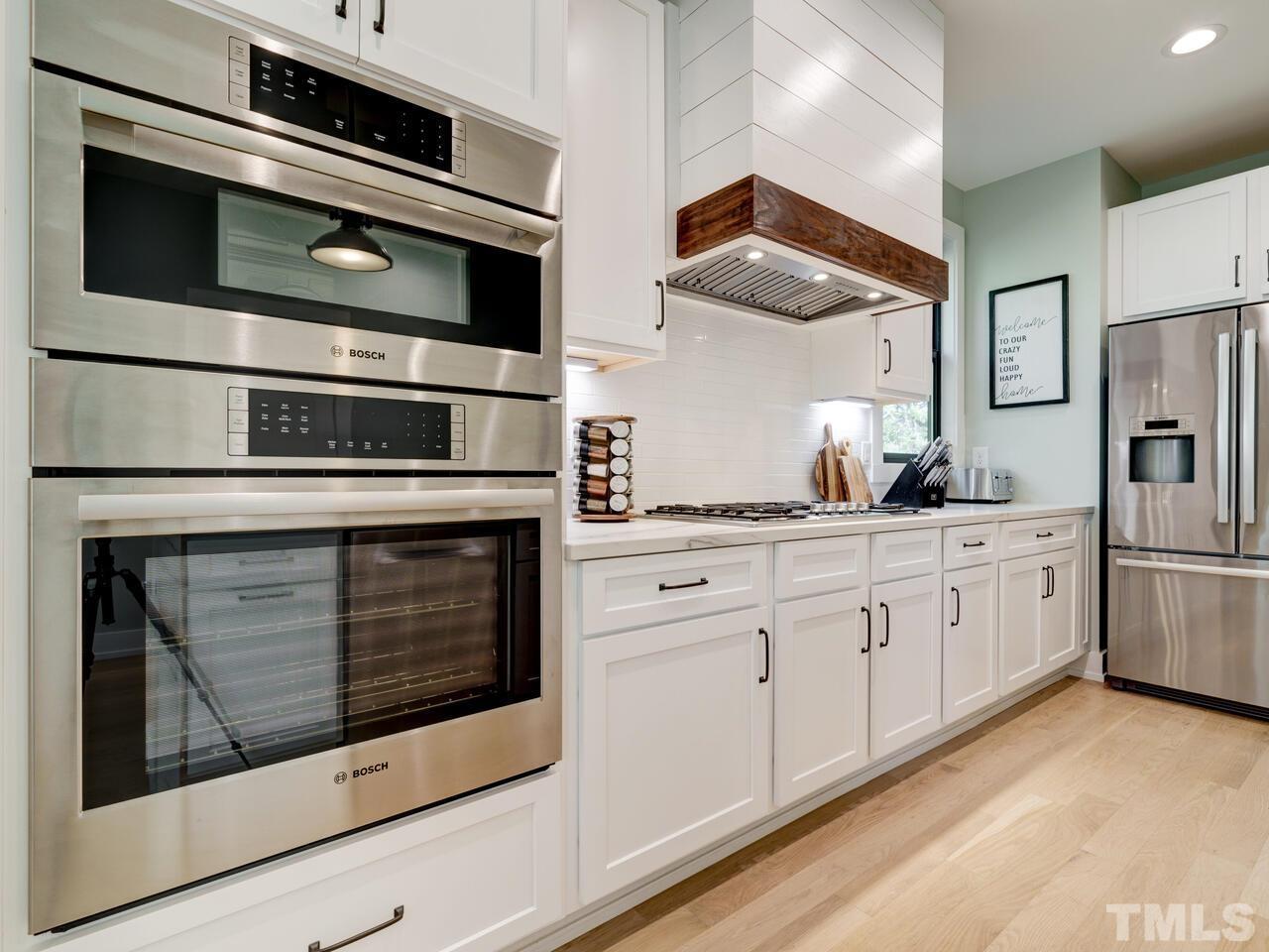 220 Hargrove Street Durham, NC 27701 - Photo 8 of 76 a kitchen with stainless steel appliances white cabinets and a stove top oven