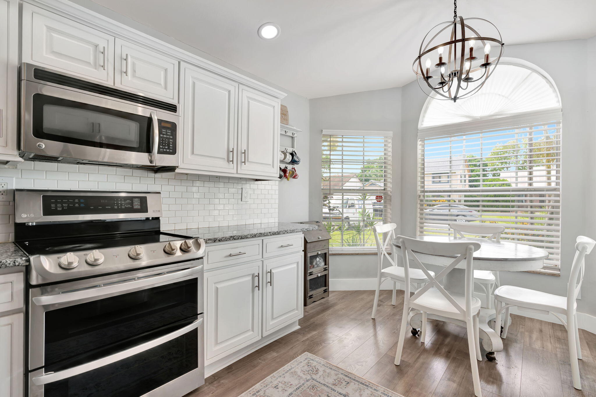 6247 Ungerer Street Jupiter, FL 33458 - Photo 17 of 36 a kitchen with stainless steel appliances a stove a sink and white cabinets